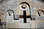 Détail du fronton occidental&nbsp;: au milieu, disque orné d’une croix sur fond végétal,  deux têtes humaines&nbsp;;  à droite&nbsp;: couple de têtes et cheval