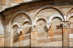 Double jeu d’arcs de l’abside : l’arc supérieur repose sur les chapiteaux sculptés des pilastres semi-engagés, les petits arcs inférieurs  sur modillons sculptés