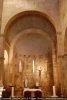Vue intérieure de l’abside précédée d’une travée droite. Arc triomphal formé de claveaux et voûte en cul de four construite de petites pierres disposées irrégulièrement