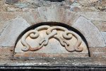 Serpents se mordant la queue (12e siècle) ; au centre inscription : RIPA... 1550 FECIT. Le thème du serpent se mordant la queue se retrouve sur d’autres tympans comme à San Cipriano de Querciltello